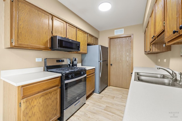 127 Village Creek Dr Unit 0, Lake In The Hills, IL 60156 - kitchen featuring appliances with stainless steel finishes, a sink, light wood-style floors, and light countertops
