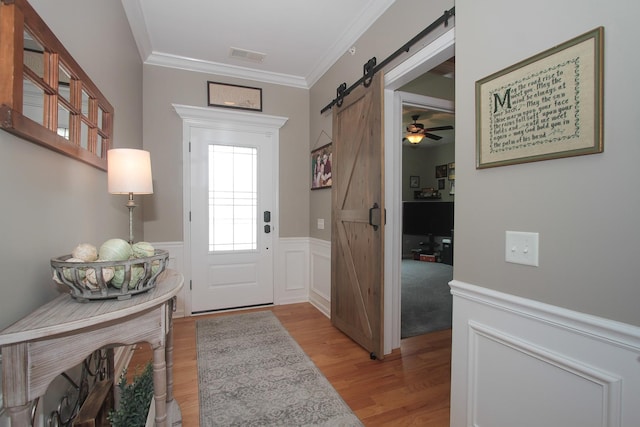 12370 Russet Ln, Huntley, IL 60142 - entrance foyer featuring a barn door, light wood finished floors, ornamental molding, wainscoting, and a decorative wall