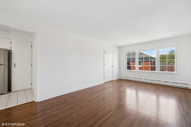 2222 Central St Unit 3, Evanston, IL 60201 - empty room with baseboard heating, wood finished floors, and baseboards