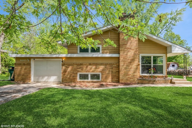 880 Marcella Rd, Merrillville, IN 46410 - view of front of property with brick siding, a garage, concrete driveway, and a front lawn