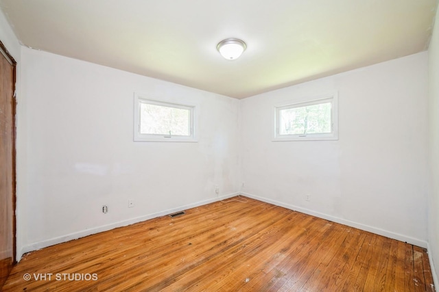 880 Marcella Rd, Merrillville, IN 46410 - unfurnished bedroom with multiple windows, light wood-type flooring, and baseboards