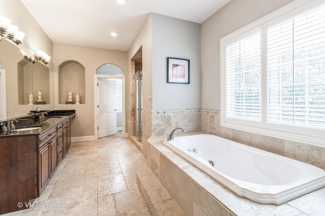 4111 Douglas Rd, Downers Grove, IL 60515 - bathroom featuring stone tile floors, a whirlpool tub, double vanity, a shower stall, and baseboards