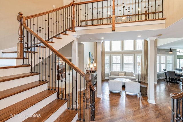 4111 Douglas Rd, Downers Grove, IL 60515 - stairs featuring a towering ceiling, a ceiling fan, baseboards, wood finished floors, and decorative columns