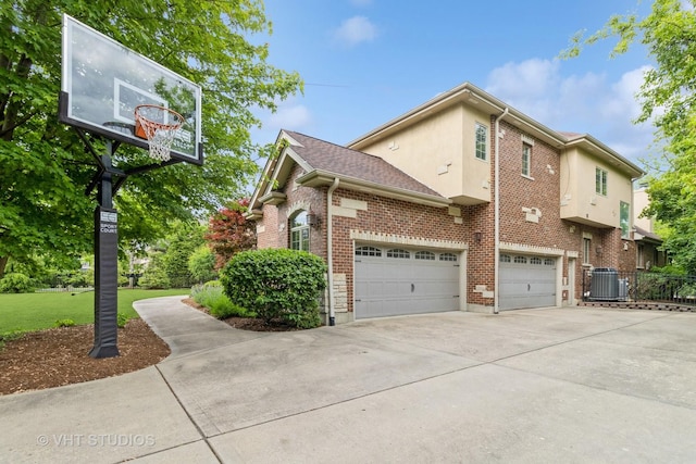 4111 Douglas Rd, Downers Grove, IL 60515 - view of side of home featuring driveway, central AC unit, stucco siding, brick siding, and an attached garage