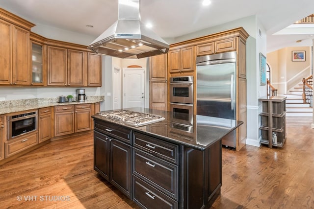 4111 Douglas Rd, Downers Grove, IL 60515 - kitchen featuring island exhaust hood, stainless steel appliances, wood finished floors, brown cabinetry, and recessed lighting