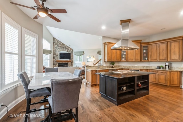 4111 Douglas Rd, Downers Grove, IL 60515 - kitchen featuring brown cabinetry, a ceiling fan, island range hood, light stone counters, and a kitchen island