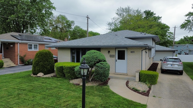 17121 Bernadine St, Lansing, IL 60438 - view of front of house featuring a front yard, brick siding, a shingled roof, and a detached garage