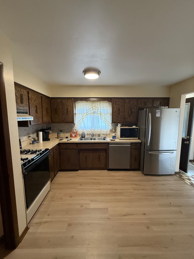 17121 Bernadine St, Lansing, IL 60438 - kitchen featuring appliances with stainless steel finishes, dark brown cabinetry, backsplash, and light wood-style flooring