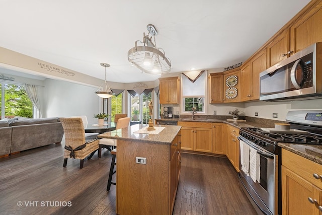 2260 Brookside Ct, Aurora, IL 60502 - kitchen with appliances with stainless steel finishes, dark wood-type flooring, open floor plan, a breakfast bar, and a sink