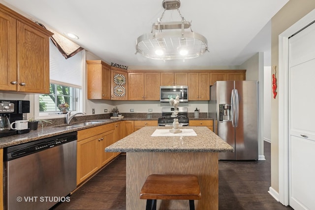 2260 Brookside Ct, Aurora, IL 60502 - kitchen featuring stainless steel appliances, a sink, a center island, dark wood-style floors, and light stone countertops