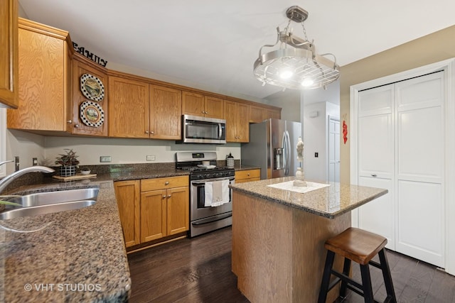 2260 Brookside Ct, Aurora, IL 60502 - kitchen featuring stainless steel appliances, a sink, a center island, dark wood-type flooring, and a kitchen bar