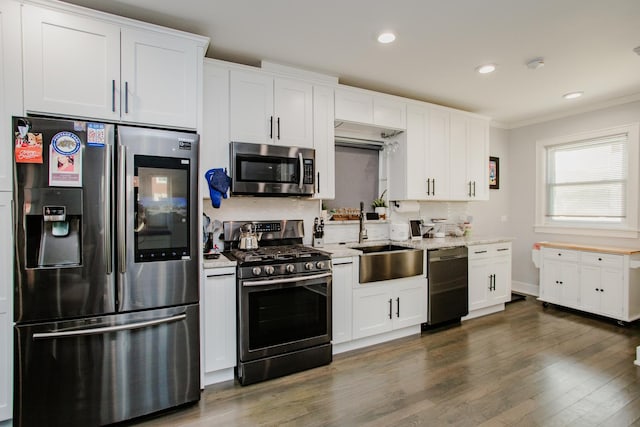 3356 N New England Ave, Chicago, IL 60634 - kitchen featuring stainless steel appliances, a sink, dark wood-style flooring, crown molding, and white cabinets