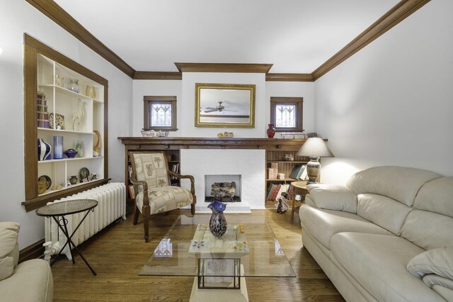 516 Clinton Ave, Oak Park, IL 60304 - living room with ornamental molding, wood finished floors, ceiling fan, a brick fireplace, and radiator