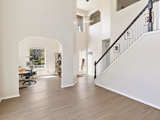 2303 Kentuck Ct, Naperville, IL 60564 - entryway with wood finished floors, a high ceiling, baseboards, arched walkways, and stairs
