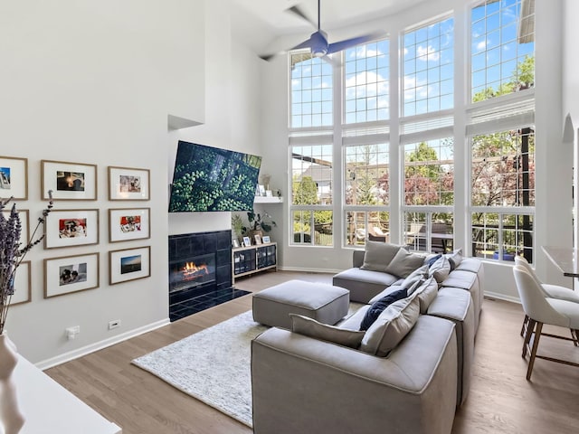 2303 Kentuck Ct, Naperville, IL 60564 - living area featuring a towering ceiling, a tiled fireplace, baseboards, and wood finished floors