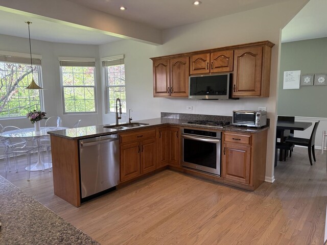 2303 Kentuck Ct, Naperville, IL 60564 - kitchen featuring stainless steel appliances, a sink, light wood-style flooring, brown cabinetry, and recessed lighting