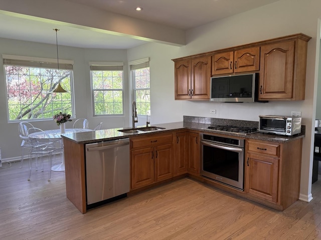 2303 Kentuck Ct, Naperville, IL 60564 - kitchen with appliances with stainless steel finishes, a sink, light wood-style flooring, a peninsula, and brown cabinetry