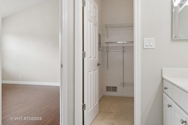 66 N Palazzo Dr, Addison, IL 60101 - bathroom with vanity, baseboards, wood finished floors, and a walk in closet