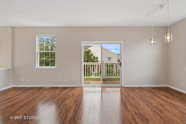 66 N Palazzo Dr, Addison, IL 60101 - unfurnished room with dark wood-style floors, healthy amount of natural light, baseboards, and rail lighting