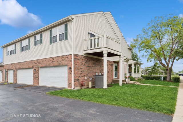 66 N Palazzo Dr, Addison, IL 60101 - view of front of home with a balcony, brick siding, a front lawn, a garage, and central air condition unit