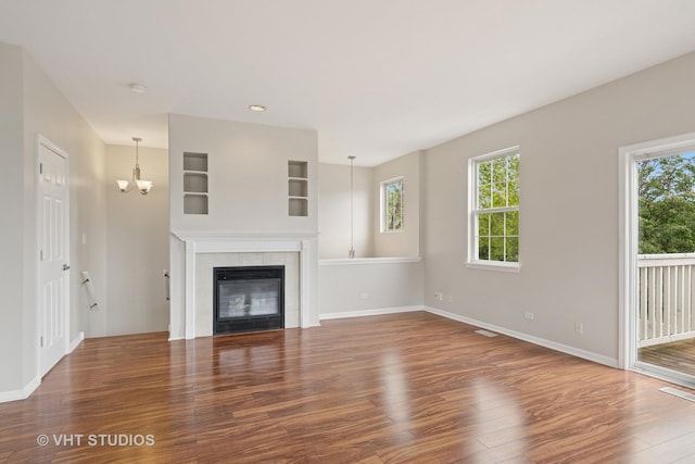 66 N Palazzo Dr, Addison, IL 60101 - unfurnished living room featuring wood finished floors, baseboards, a chandelier, and a fireplace