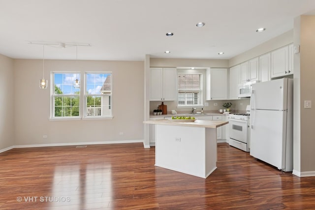 66 N Palazzo Dr, Addison, IL 60101 - kitchen with white appliances, dark wood-style flooring, white cabinets, a kitchen island, and recessed lighting