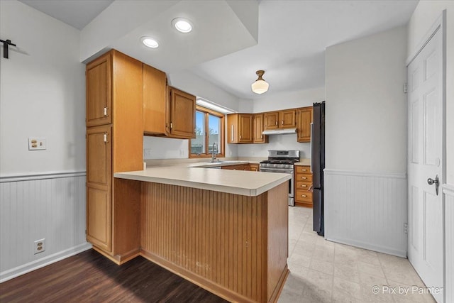 1315 W Galena Blvd, Aurora, IL 60506 - kitchen featuring gas stove, under cabinet range hood, a peninsula, a wainscoted wall, and light countertops