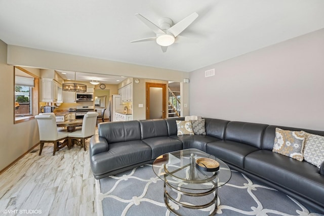 2950 Becket Ave, Westchester, IL 60154 - living room featuring light wood-style floors, ceiling fan, stairs, baseboards, and a chandelier