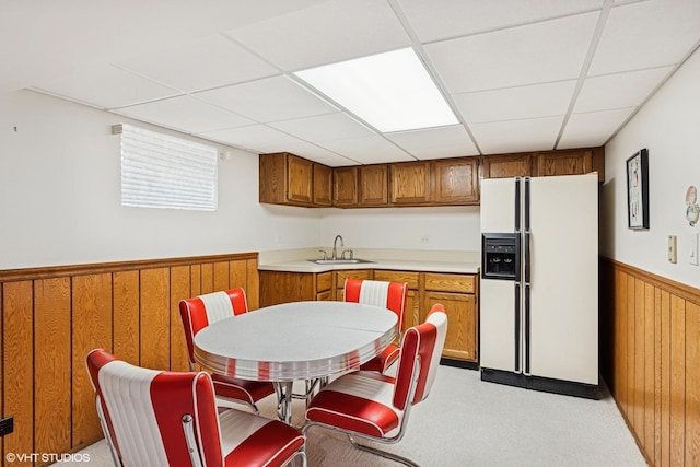2950 Becket Ave, Westchester, IL 60154 - kitchen featuring white fridge with ice dispenser, a sink, brown cabinetry, a wainscoted wall, and a paneled ceiling