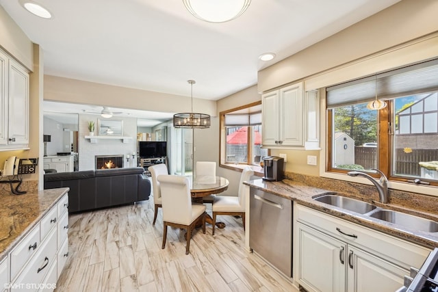 2950 Becket Ave, Westchester, IL 60154 - kitchen featuring dishwasher, a sink, a large fireplace, light stone countertops, and pendant lighting