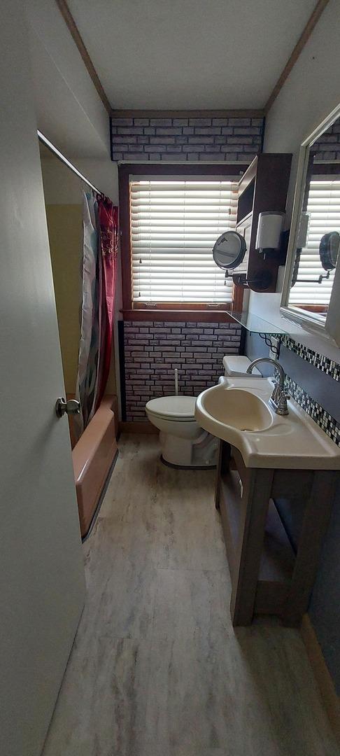 704 S Neltnor Blvd, West Chicago, IL 60185 - bathroom with toilet, wood finished floors, vanity, shower / bath combo with shower curtain, and ornamental molding