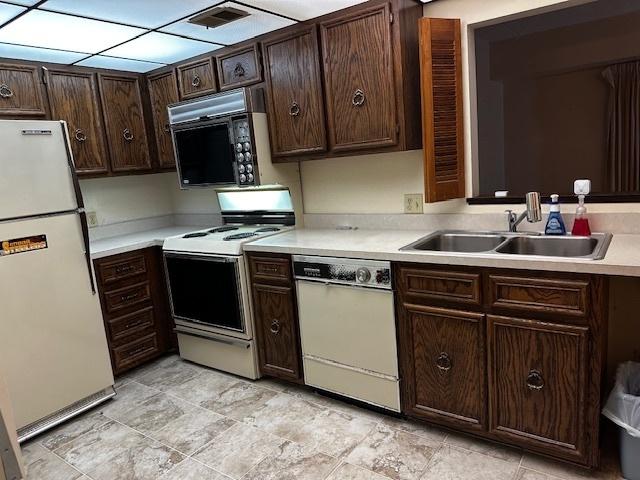1423 Woodbridge Rd Unit 1F, Joliet, IL 60436 - kitchen with white appliances, light countertops, a sink, and dark brown cabinets