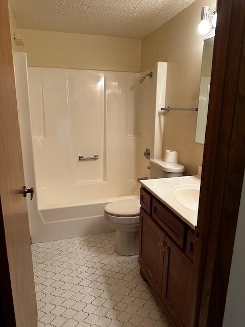 1423 Woodbridge Rd Unit 1F, Joliet, IL 60436 - bathroom featuring a textured ceiling, toilet, shower / tub combination, and vanity