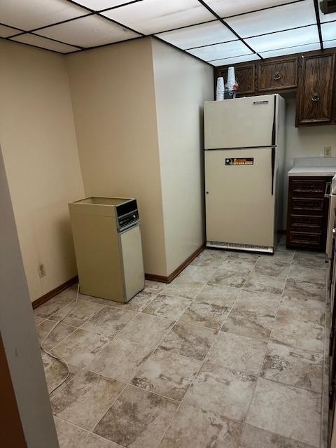 1423 Woodbridge Rd Unit 1F, Joliet, IL 60436 - kitchen featuring freestanding refrigerator, dark brown cabinets, baseboards, and light countertops