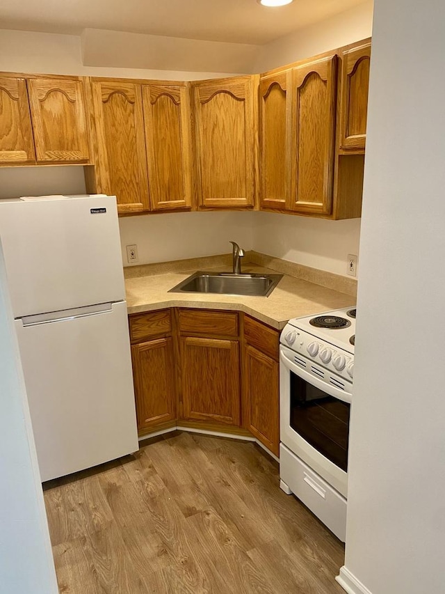 910 Market St, Dekalb, IL 60115 - kitchen with white appliances, a sink, light countertops, and light wood-style flooring