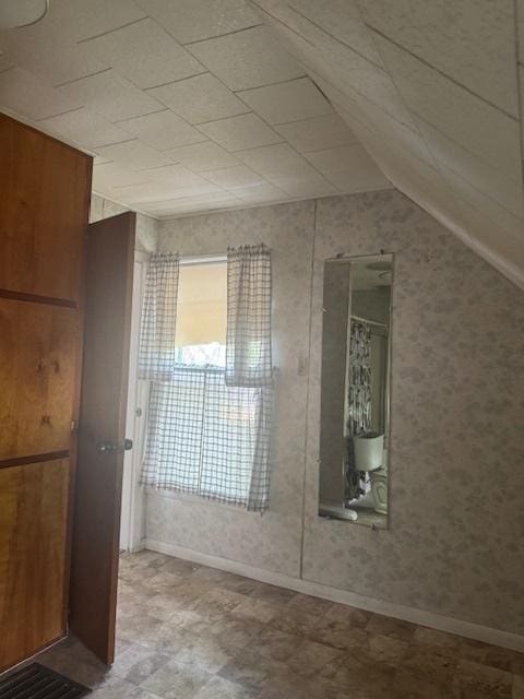 303 W Prairie St, Pontiac, IL 61764 - bathroom featuring baseboards and vaulted ceiling