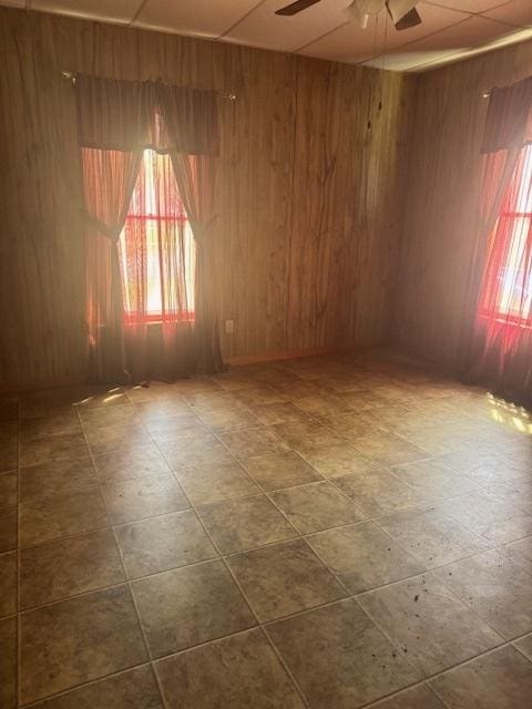 303 W Prairie St, Pontiac, IL 61764 - spare room featuring a ceiling fan, healthy amount of natural light, and wooden walls