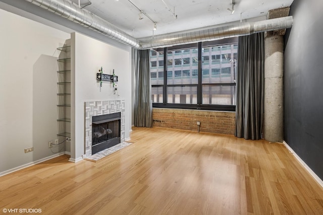130 S Canal St Unit 216, Chicago, IL 60606 - unfurnished living room with wood finished floors, a fireplace with flush hearth, track lighting, and baseboards