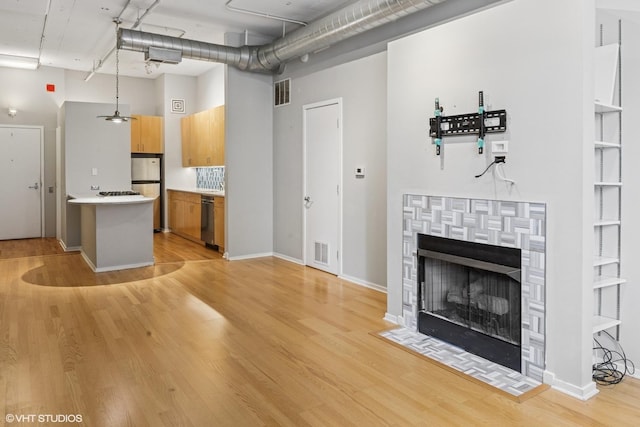 130 S Canal St Unit 216, Chicago, IL 60606 - unfurnished living room featuring a high ceiling, light wood-type flooring, a tiled fireplace, and baseboards