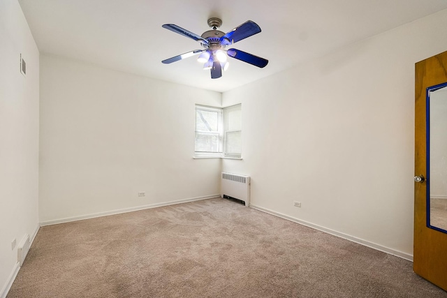 spare room with radiator, ceiling fan, carpet floors, and baseboards