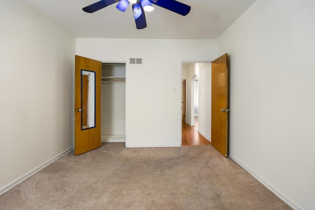 unfurnished bedroom featuring carpet flooring, arched walkways, a closet, baseboards, and ceiling fan