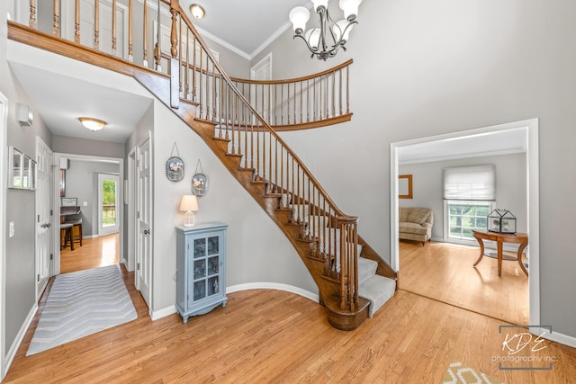 1309 Brunswick Ct, Naperville, IL 60540 - staircase featuring wood finished floors, plenty of natural light, a high ceiling, a chandelier, and baseboards