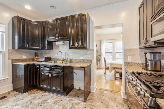 523 Spruce St, Aurora, IL 60506 - kitchen featuring appliances with stainless steel finishes, a sink, light stone countertops, backsplash, and recessed lighting
