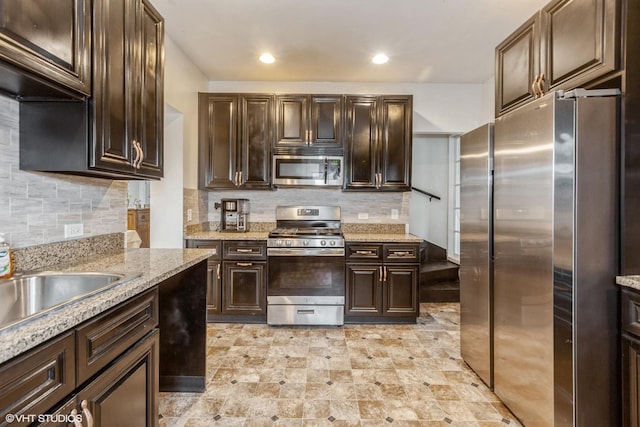 523 Spruce St, Aurora, IL 60506 - kitchen with appliances with stainless steel finishes, dark brown cabinetry, backsplash, light stone counters, and recessed lighting