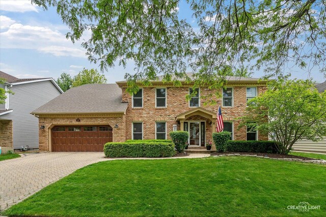 2255 University Dr, Naperville, IL 60565 - colonial inspired home featuring a garage, brick siding, a front yard, and decorative driveway
