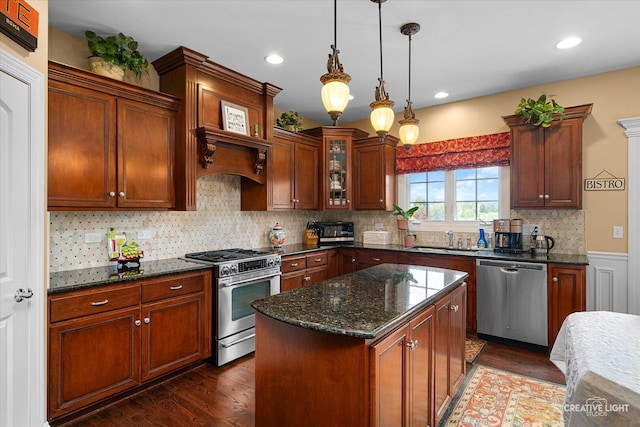25700 Pastoral Dr, Plainfield, IL 60585 - kitchen featuring stainless steel appliances, dark wood finished floors, dark stone countertops, hanging light fixtures, and glass insert cabinets