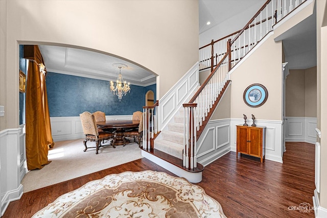 25700 Pastoral Dr, Plainfield, IL 60585 - entrance foyer with arched walkways, wood finished floors, a chandelier, stairway, and a wainscoted wall
