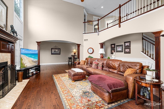25700 Pastoral Dr, Plainfield, IL 60585 - living area with decorative columns, wood finished floors, a fireplace, arched walkways, and a high ceiling