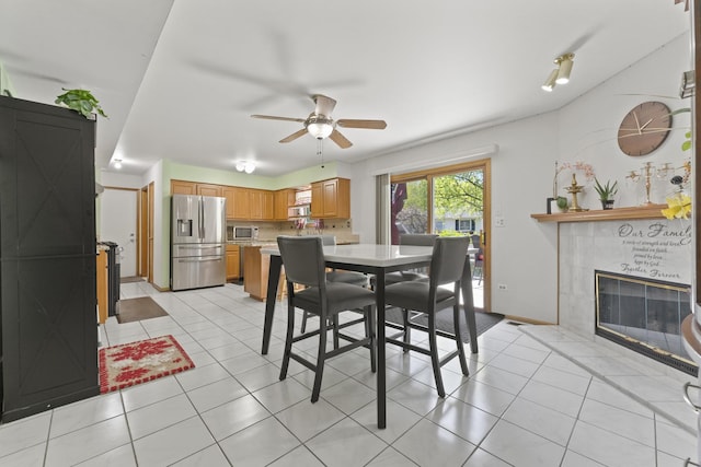 630 S Walnut Ln, Schaumburg, IL 60193 - dining room featuring a fireplace, ceiling fan, and light tile patterned floors