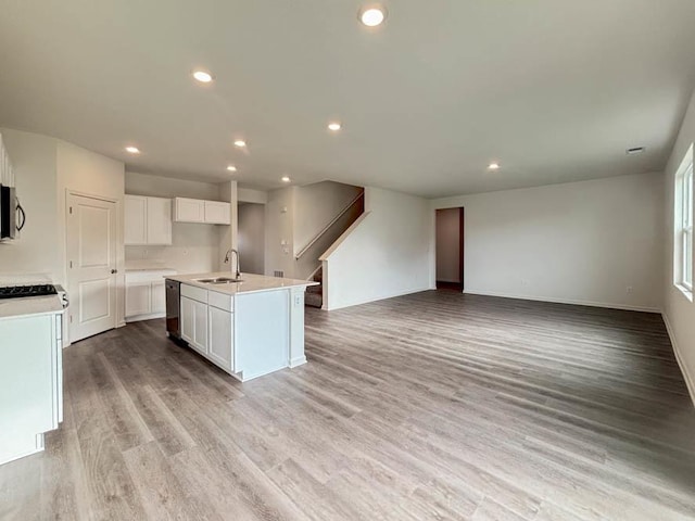 6900 Willow Dr, Wonder Lake, IL 60097 - kitchen featuring stainless steel microwave, open floor plan, a sink, an island with sink, and light wood-style flooring